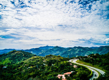 High angle view of road amidst trees against sky