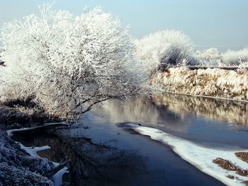 Scenic view of river against sky during winter