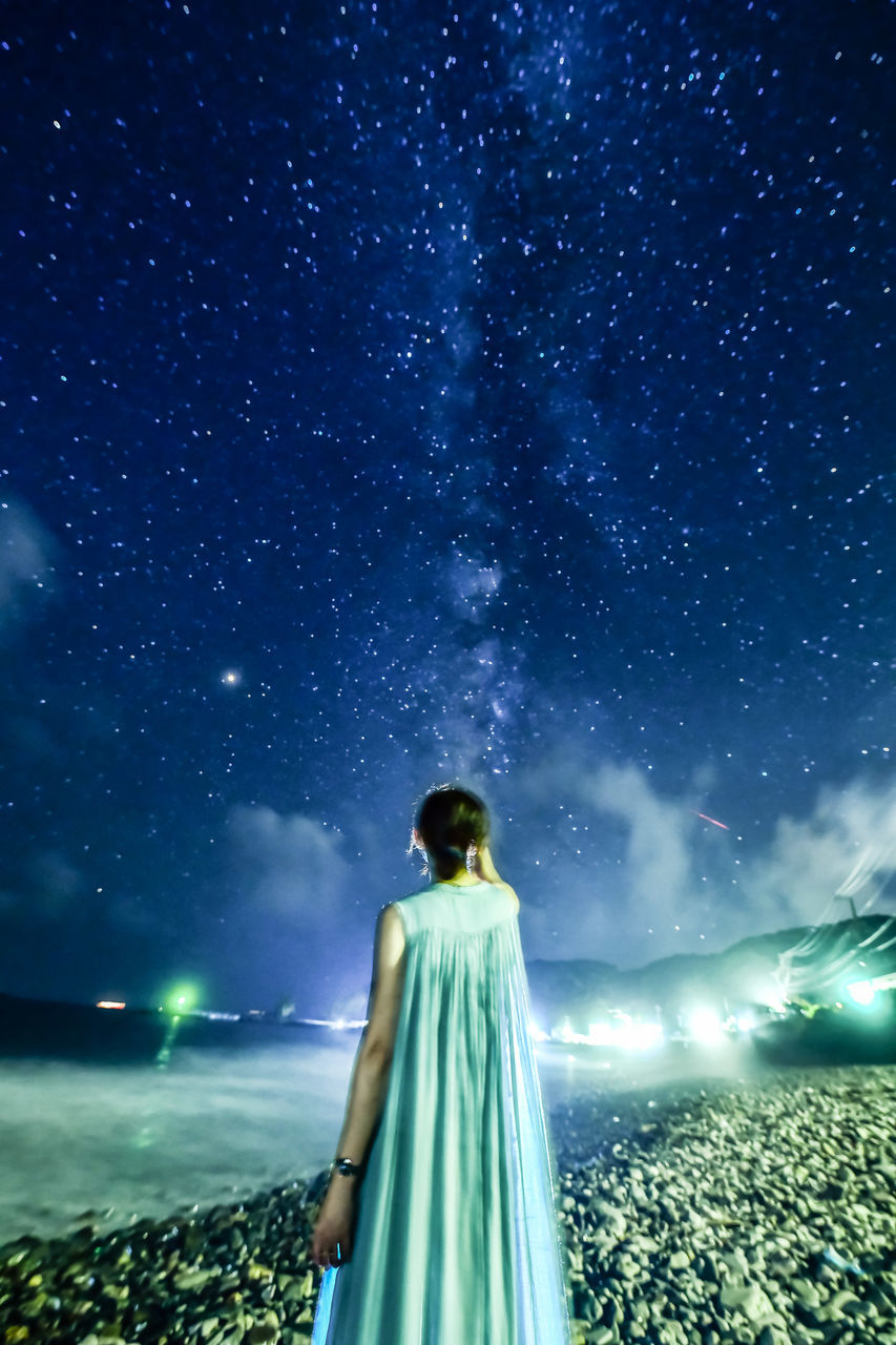 star - space, one person, night, rear view, sky, young adult, space, astronomy, nature, standing, scenics - nature, illuminated, galaxy, adult, star field, star, beauty in nature, constellation, three quarter length, outdoors, milky way, looking at view, digital composite