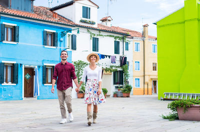 Young couple smiling on footpath in city