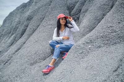 Full length portrait of woman sitting outdoors