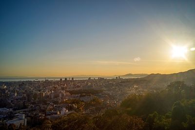 Aerial view of cityscape against clear sky during sunset