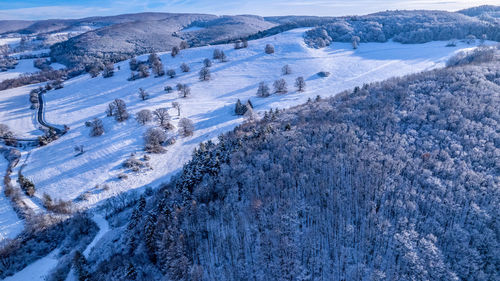 Aerial winter landscape. road leading through snowcapped winter forest. aerial view. 