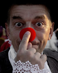 Close-up portrait of man holding red hand