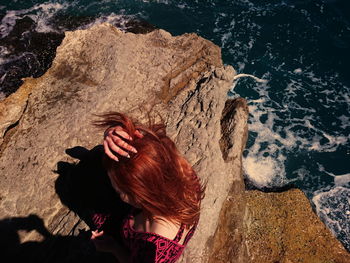 Rear view of young woman looking at sea