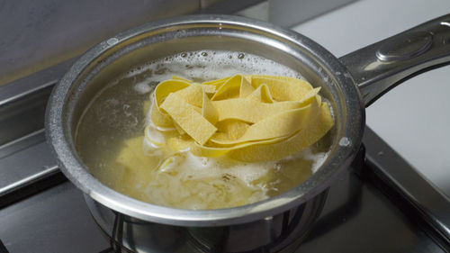 High angle view of pasta boiling in container on gas