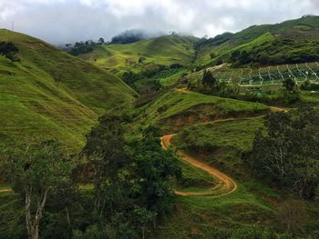 Scenic view of green landscape and mountains against sky