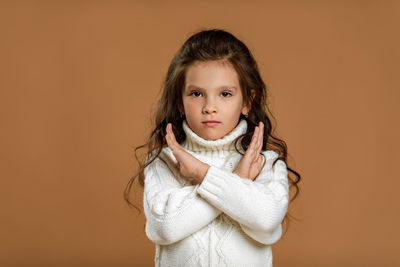 Portrait of young woman against yellow background