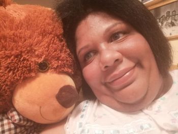 Close-up portrait of a smiling young woman with toy