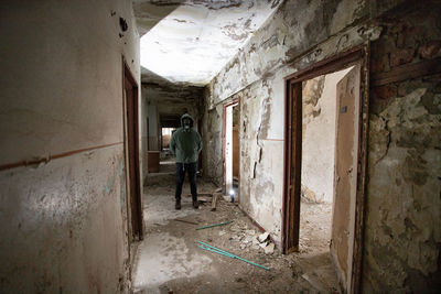 Man wearing gas mask standing in abandoned building
