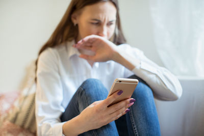 Woman using mobile phone at home