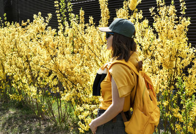 Side view of man standing amidst plants