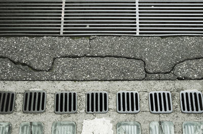 High angle view of metal grate on sidewalk