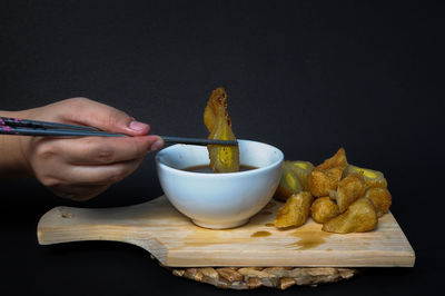 Close-up of person holding food on table