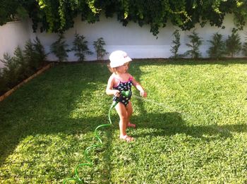 Rear view of girl walking on grassy field