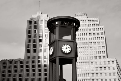 Low angle view of clock tower against buildings in city