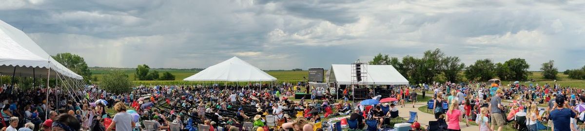 Panoramic view of crowd at concert against sky