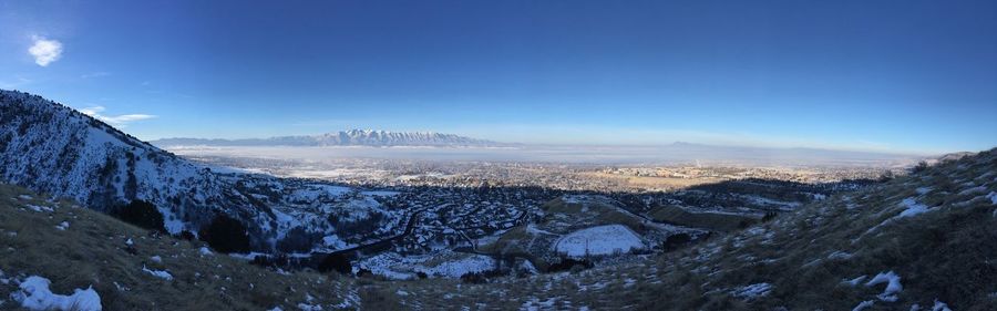 Panoramic view of landscape against blue sky during winter