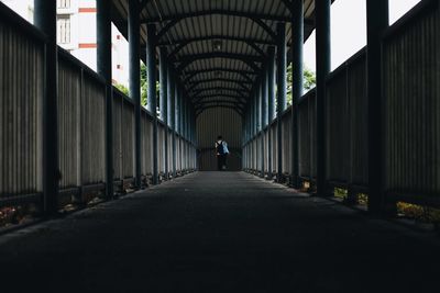 Rear view of man walking on bridge