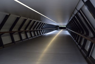 Diminishing perspective of empty footbridge at night