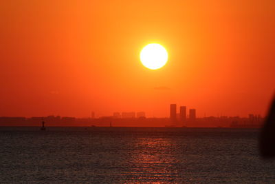 Scenic view of sea against orange sky