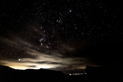 Low angle view of silhouette trees against sky at night