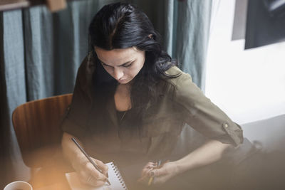 Woman looking away while sitting at home