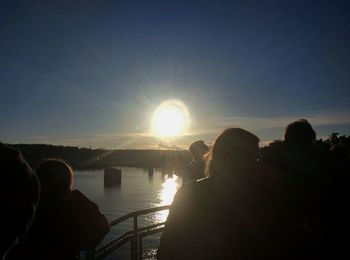 People on shore against sky