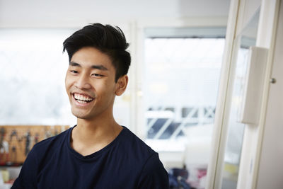 Smiling young man standing in university laboratory