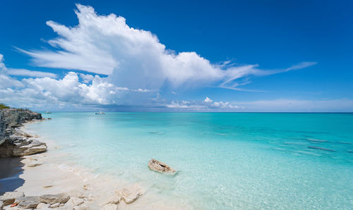 White sandy beach with blue ocean and white clouds 