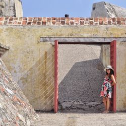 Young woman standing amidst doorway of historical building