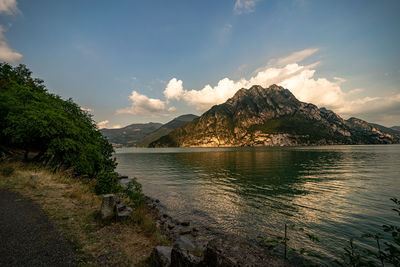 Scenic view of lake by mountains against sky