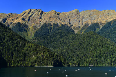 Scenic view of lake and mountains against clear sky