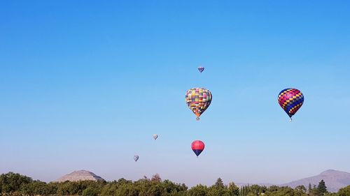 Low angle view of hot air balloons flying in sky