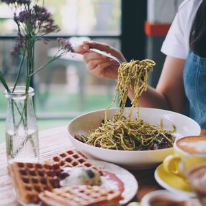 Midsection of man having food in restaurant