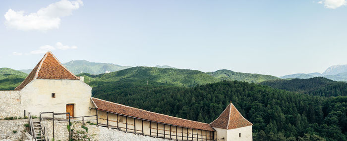 Traditional building by mountains against sky