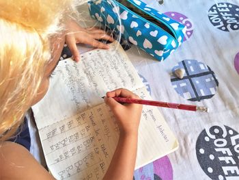 High angle view of girl studying at table