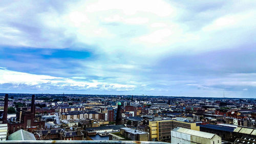 Aerial view of city against cloudy sky