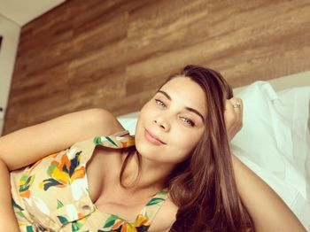 Portrait of young woman relaxing on bed at home