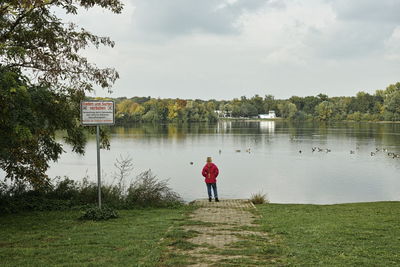 Rear view of woman overlooking calm lake