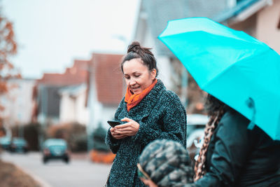 Young woman using mobile phone in city