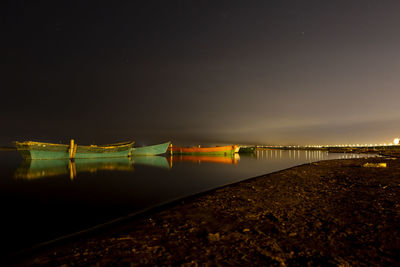 Bridge over river against sky at night