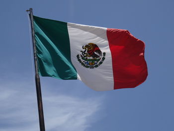 Low angle view of mexican flag against blue sky