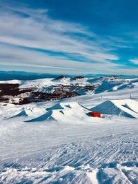 Scenic view of snow covered landscape against blue sky