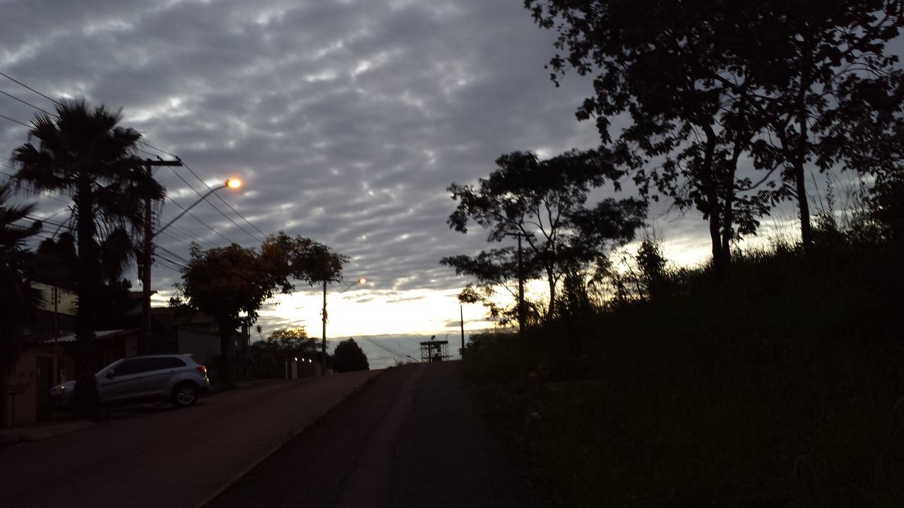 transportation, tree, the way forward, road, sky, car, street, diminishing perspective, sunset, land vehicle, silhouette, cloud - sky, palm tree, vanishing point, road marking, mode of transport, cloud, treelined, outdoors, growth