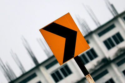 Low angle view of road sign against sky