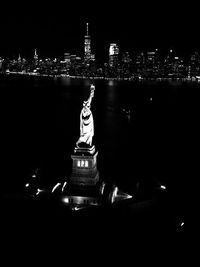 Statue of illuminated cityscape at night