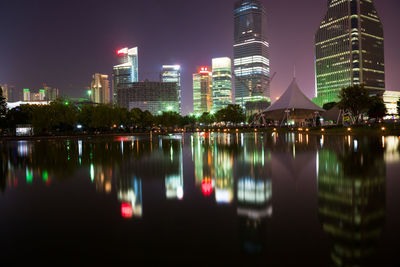 Reflection of illuminated buildings in city at night