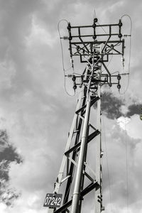 Low angle view of power lines against cloudy sky