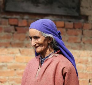 Portrait of smiling woman against wall